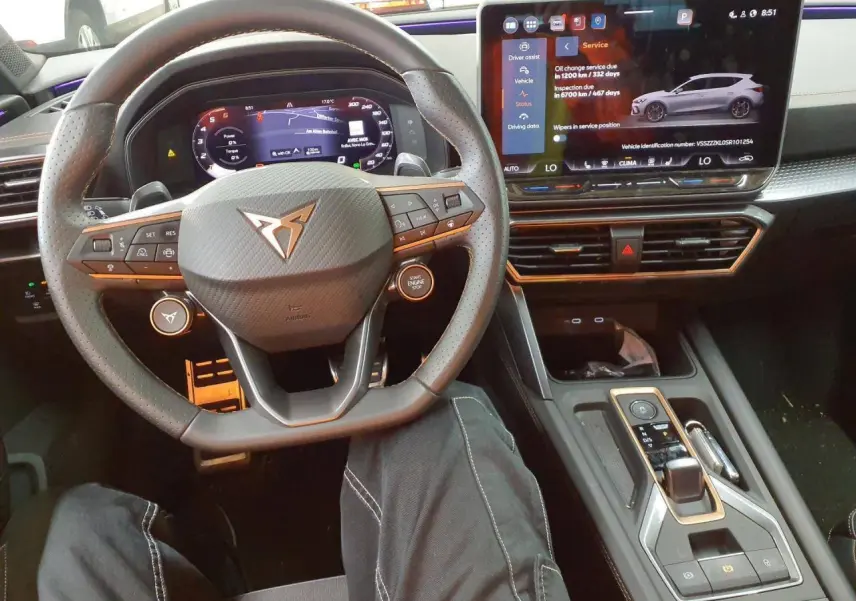 Vue intérieure centrée sur le volant cuir perforé CUPRA et l'écran tactile digital du tableau de bord.