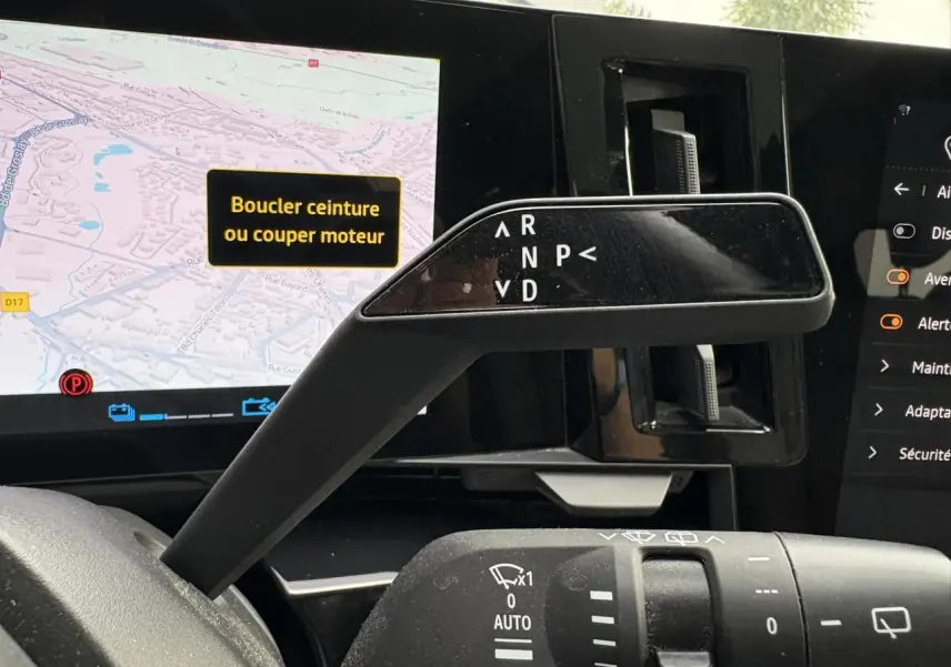 Le levier de vitesses automatique et commandes d'essuie-glace du Renault Espace E-Tech 2023, avec écran tactile en arrière-plan.