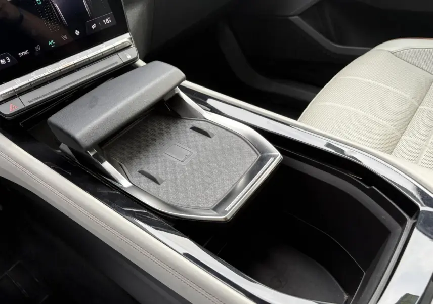 Gros plan sur la console centrale du Renault Espace 2023, avec chargeur à induction et sellerie cuir gris sable clair.