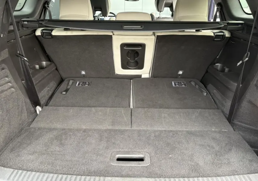 Coffre spacieux du Renault Espace E-Tech 2023 avec sièges arrière rabattus et sellerie claire visible à l'avant.