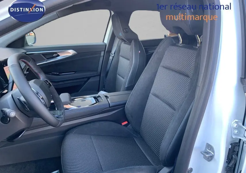 Vue intérieure côté conducteur du Renault Austral 2024 blanc métal, sièges noirs en tissu et alcantara avec surpiqûres bleues.