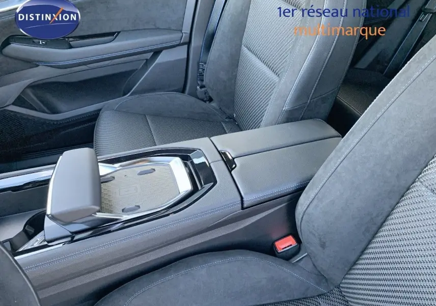 Intérieur du Renault Austral 2024, vue rapprochée de la console centrale et des sièges en tissu noir avec surpiqûres bleues.