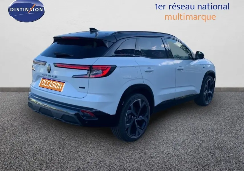 Vue 3/4 arrière droite du Renault Austral blanc métal avec toit noir et jantes noires distinctives.