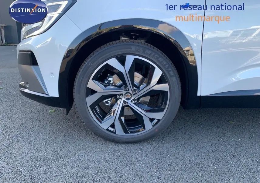 Gros plan sur la roue avant droite du Renault Austral blanc métal avec jante alliage noire et argentée.