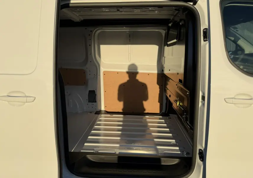 Vue intérieure arrière du Citroën Jumpy XL blanc Icy, montrant l'espace de chargement vide avec parois protégées.