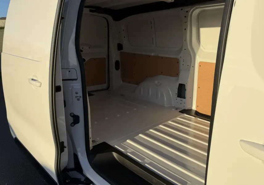Vue intérieure de la zone de chargement du Citroën Jumpy XL blanc Icy, avec porte latérale droite ouverte.