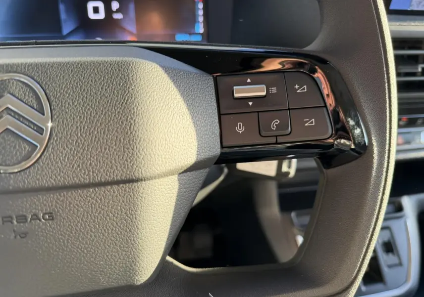 Gros plan sur la partie droite du volant gris du Citroën Jumpy 2025 avec commandes audio et téléphone intégrées.