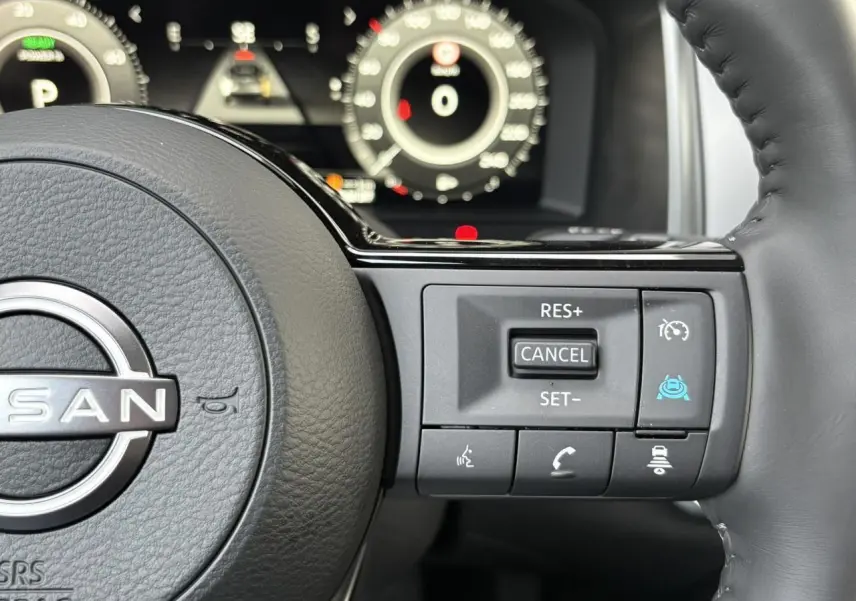 Gros plan sur le volant cuir noir du Nissan Qashqai 2025, avec commandes de régulateur et assistance à la conduite.