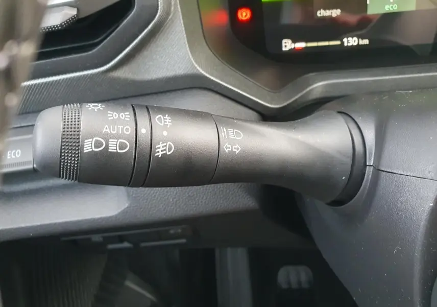 Gros plan sur la commande des feux et clignotants du tableau de bord du Dacia Bigster 2026, intérieur noir.