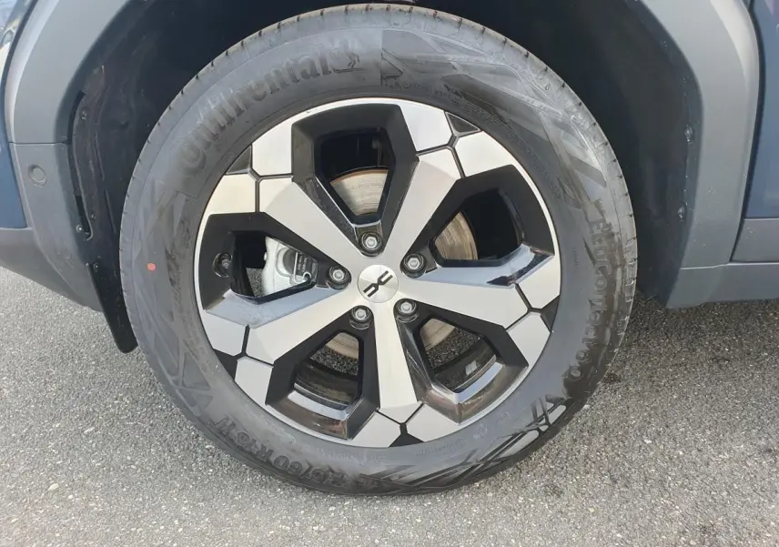 Gros plan sur la jante alliage 18” diamantée Tagasan du côté avant droit du Dacia Bigster bleu indigo.