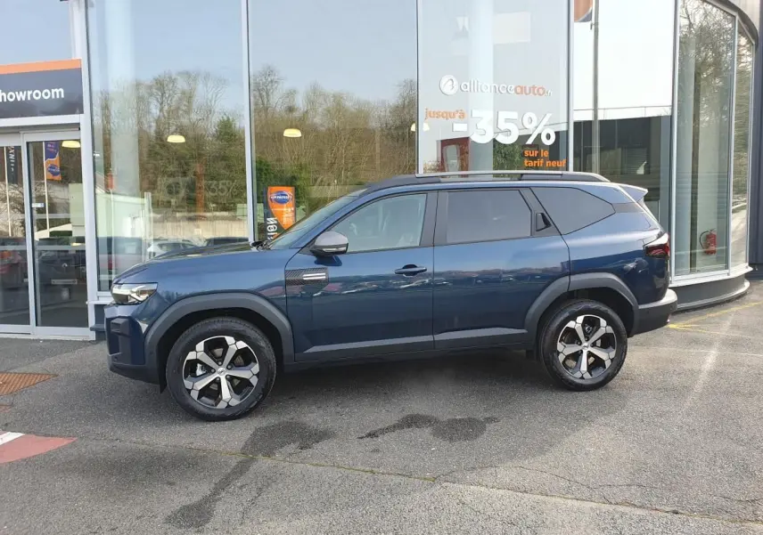 Vue de profil côté gauche d’un Dacia Bigster bleu indigo avec jantes alliage 18” et toit panoramique.