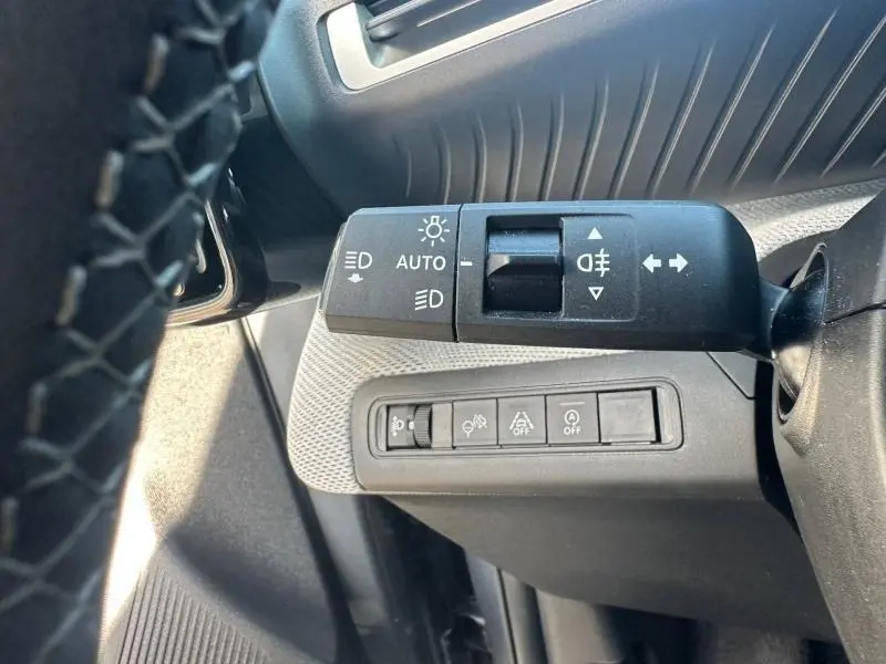 Gros plan sur la commande des feux et des clignotants à gauche du volant dans l’habitacle noir d’une Citroën C3 2025.