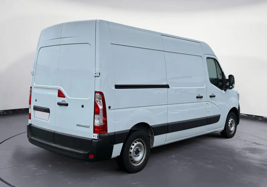 Renault Master blanc en vue 3/4 arrière droit, fourgon utilitaire avec bande noire latérale et feux arrière verticaux.