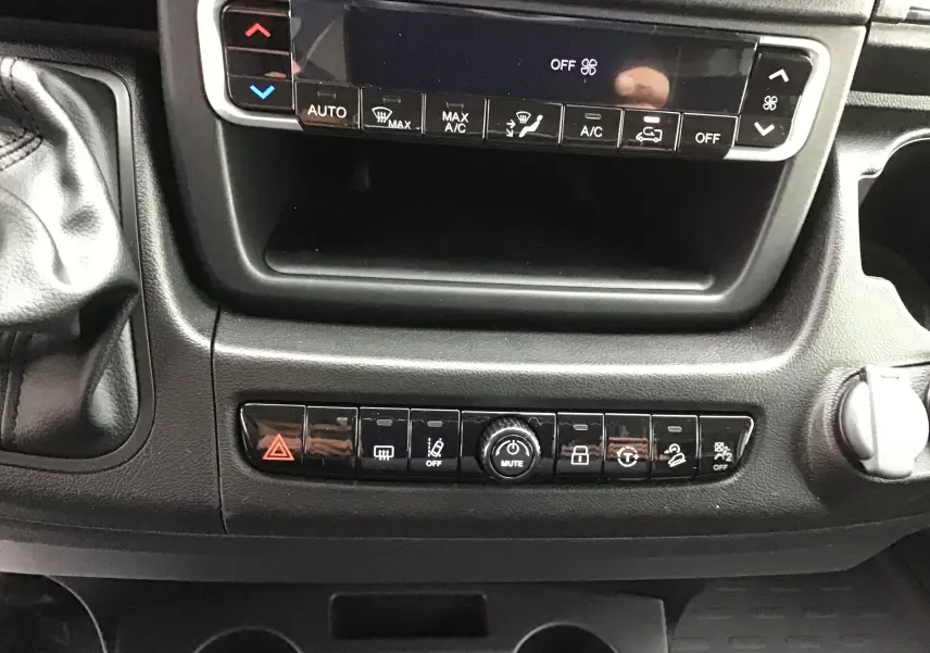 Tableau de bord du Peugeot Boxer Fourgon blanc 2025, vue rapprochée des commandes climatisation et boutons multifonctions.