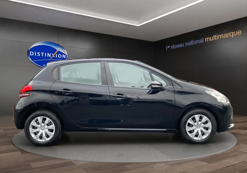 Profil latéral droit d'une Peugeot 208 Affaire Premium Pack noire, cinq portes, en intérieur showroom.