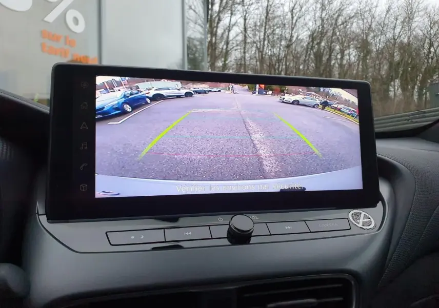 Écran tactile 12,3'' affichant la caméra de recul du Nissan Juke 2025, intérieur avec tableau de bord gris.