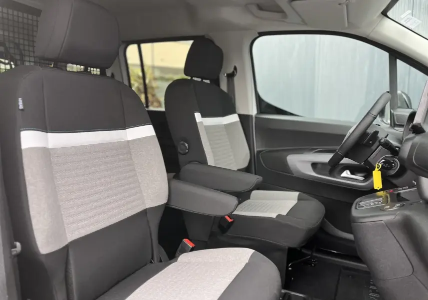 Vue intérieure côté conducteur du Citroën Berlingo Multispace 2025, sièges bi-ton gris et noir avec accoudoirs.