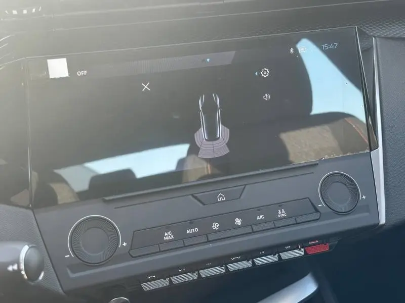 Vue rapprochée de l’écran tactile central et des commandes de climatisation d’une Peugeot 308 bleu 2025.