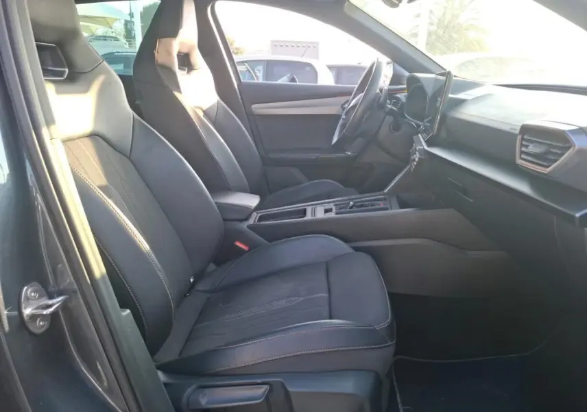 Vue intérieure côté conducteur de la CUPRA Formentor gris foncé 2023, sièges sport noirs et tableau de bord moderne.