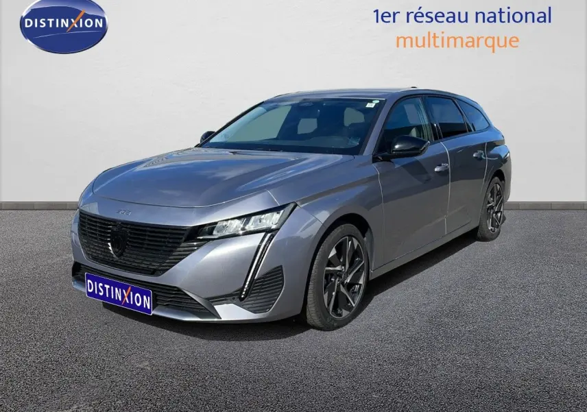 Peugeot 308 SW Hybrid gris Artense métal vue 3/4 avant droit avec jantes alliage et calandre noire distinctive.