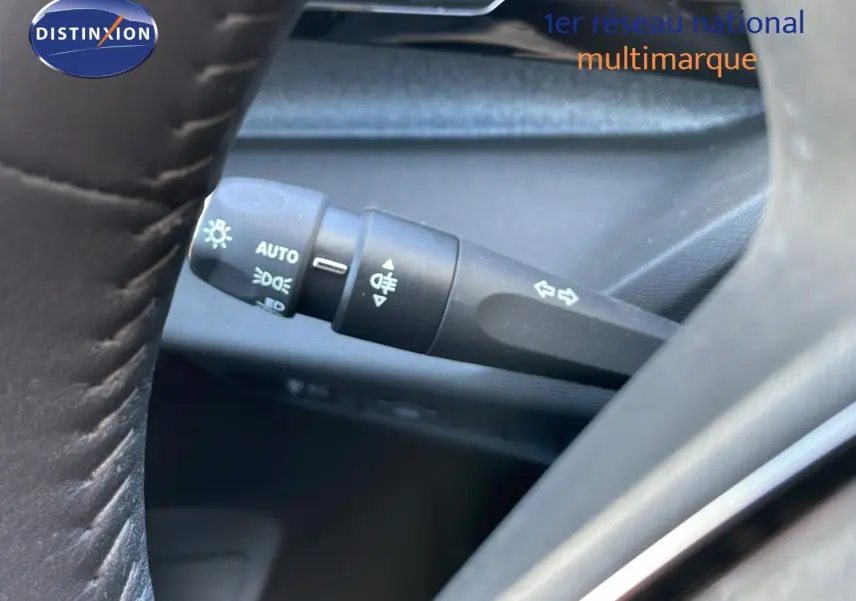Gros plan sur la commande des feux et clignotants côté gauche du volant d’un Peugeot 308 SW gris Artense 2025.