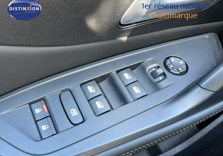 Gros plan sur les commandes de lève-vitres et rétroviseurs côté conducteur d’un Peugeot 308 SW gris Artense.