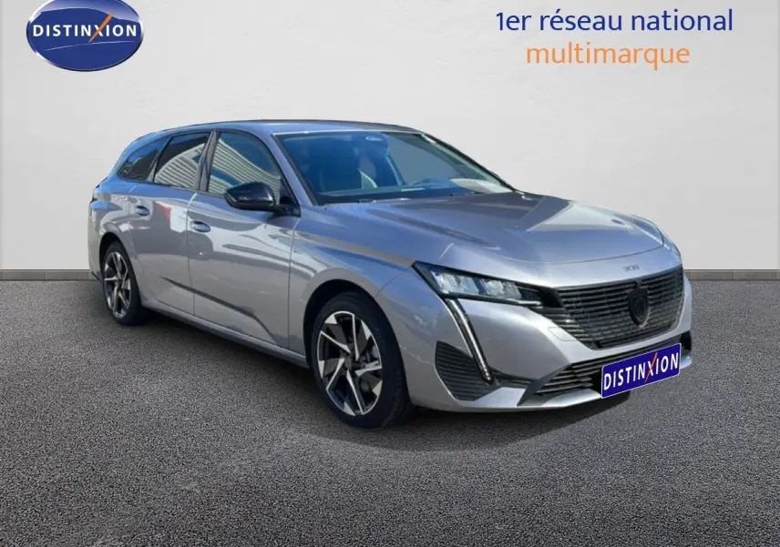 Peugeot 308 SW gris Artense métal vue 3/4 avant droit, soulignant sa calandre noire et ses jantes bicolores.