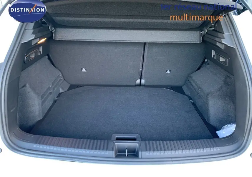 Coffre ouvert d'un Renault Austral 2024 blanc métal avec toit noir, montrant un espace de chargement propre et spacieux.