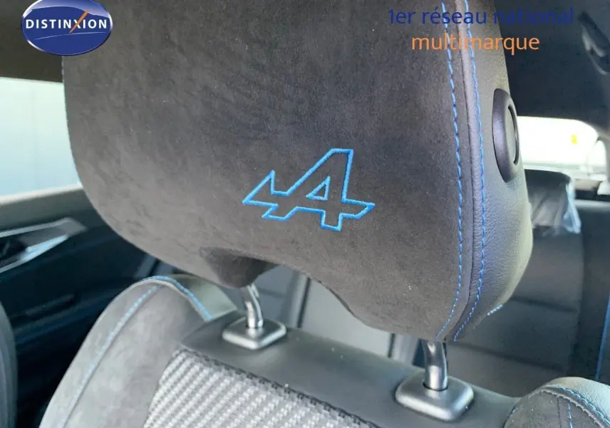 Gros plan sur l'appui-tête noir avec logo bleu "A" et surpiqûres bleues dans l'habitacle du Renault Austral 2024.