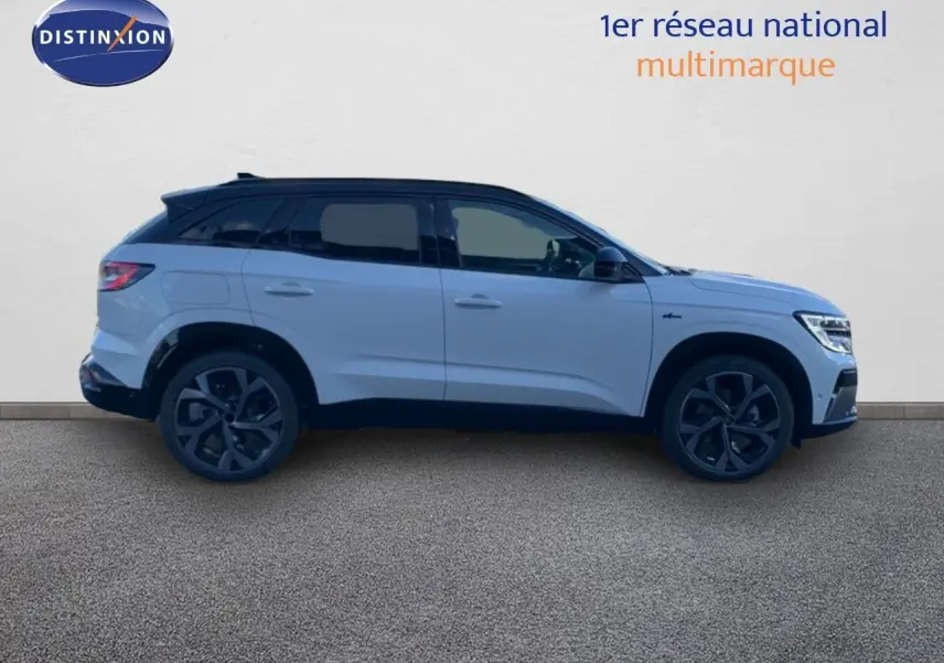 Profil côté droit du Renault Austral 2024 blanc métal avec toit noir, soulignant ses jantes noires et lignes modernes.