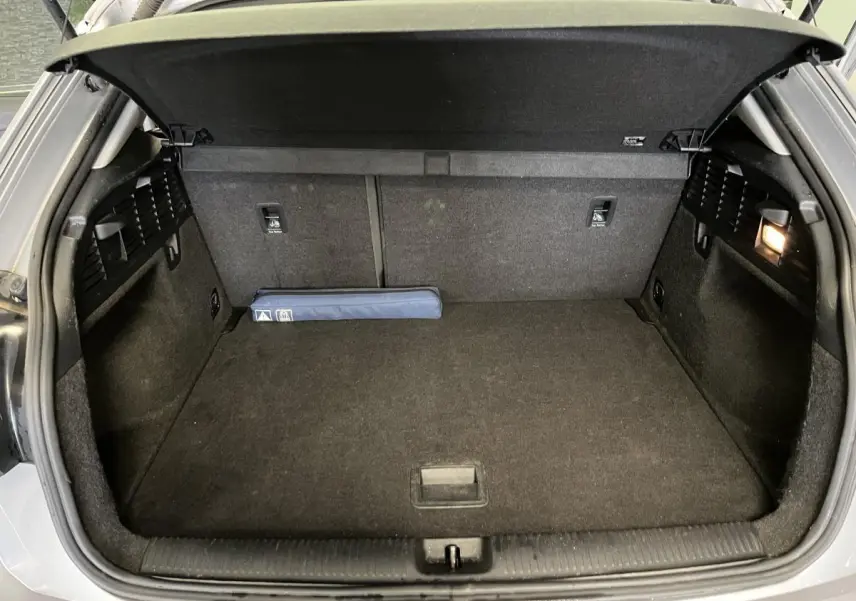 Coffre ouvert de l'Audi Q2 gris, vue arrière montrant un espace de chargement propre et éclairé à droite.