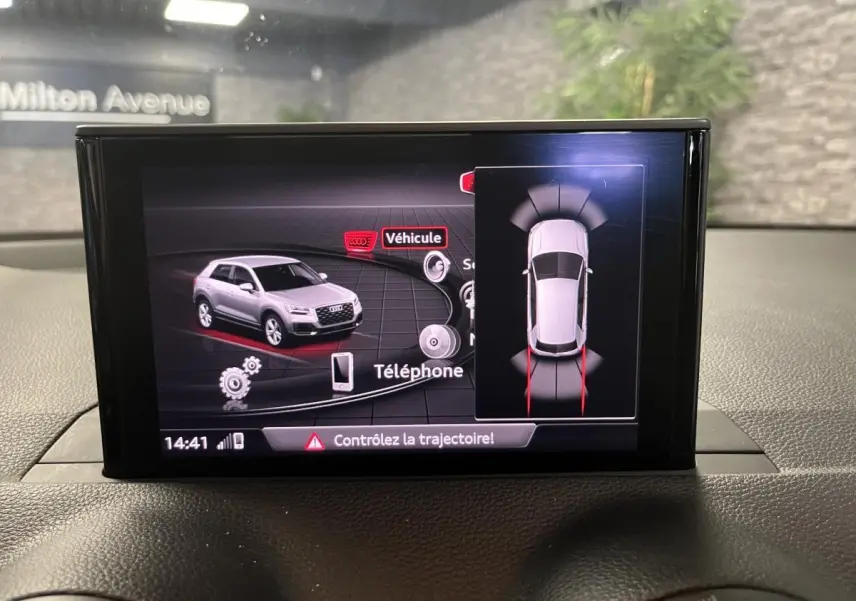 Écran central montrant l'affichage du système d'aide au stationnement de l'Audi Q2 gris de 2019.