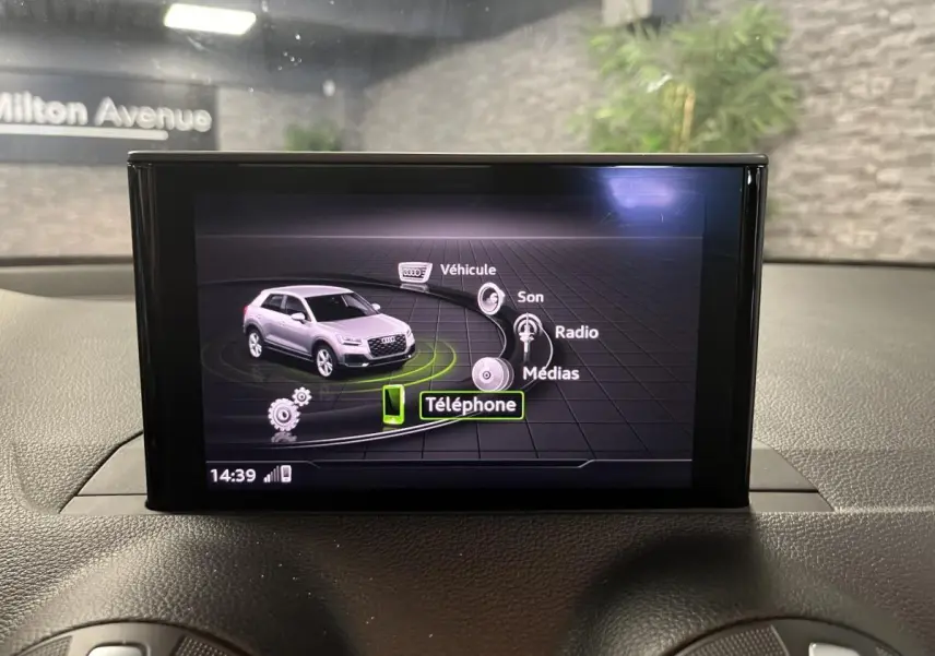 Écran central de l'Audi Q2 2019 affichant le menu multimédia avec icônes pour véhicule, son, radio et téléphone.