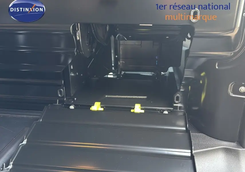 Gros plan sur l'espace de chargement intérieur noir du Citroën Jumpy Fourgon XL gris titane, montrant la cloison et les fixations.