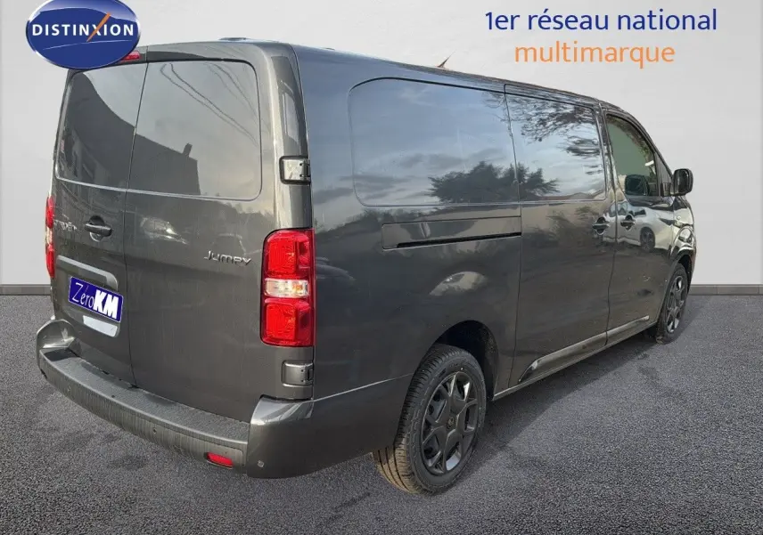 Vue 3/4 arrière droite d'un Citroën Jumpy Fourgon XL gris titane métal avec feux arrière rouges et jantes noires.