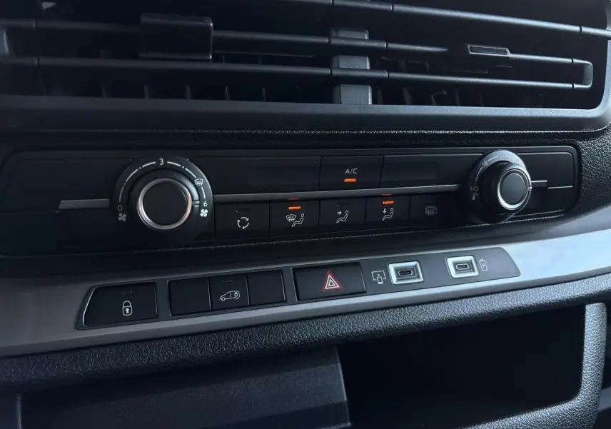 Vue rapprochée de la console centrale noire du Citroën Jumpy XL 2025 avec commandes climatisation et boutons fonctionnels.