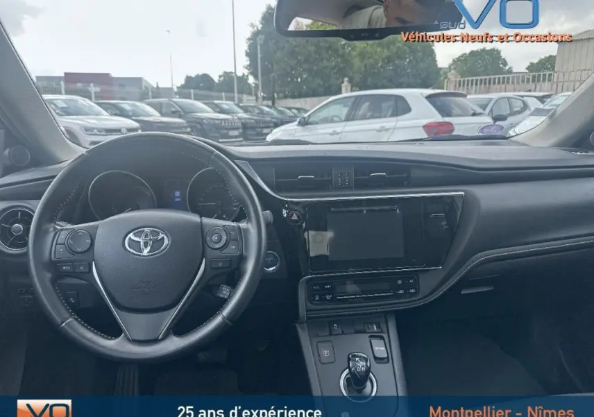 Intérieur de la Toyota Auris Business Hybride 2016, vue du tableau de bord et volant multifonctions noir.