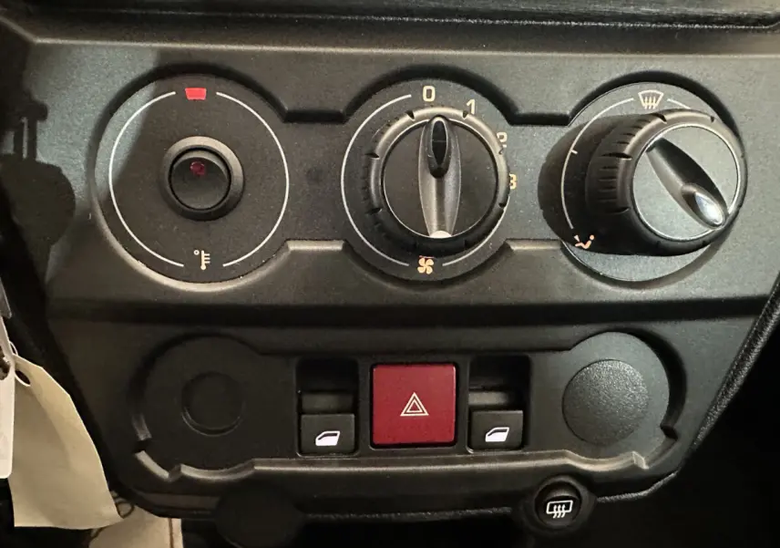 Tableau de bord de l'AIXAM AMBITION E CITY PACK 2025 avec commandes de climatisation et boutons de vitres électriques.