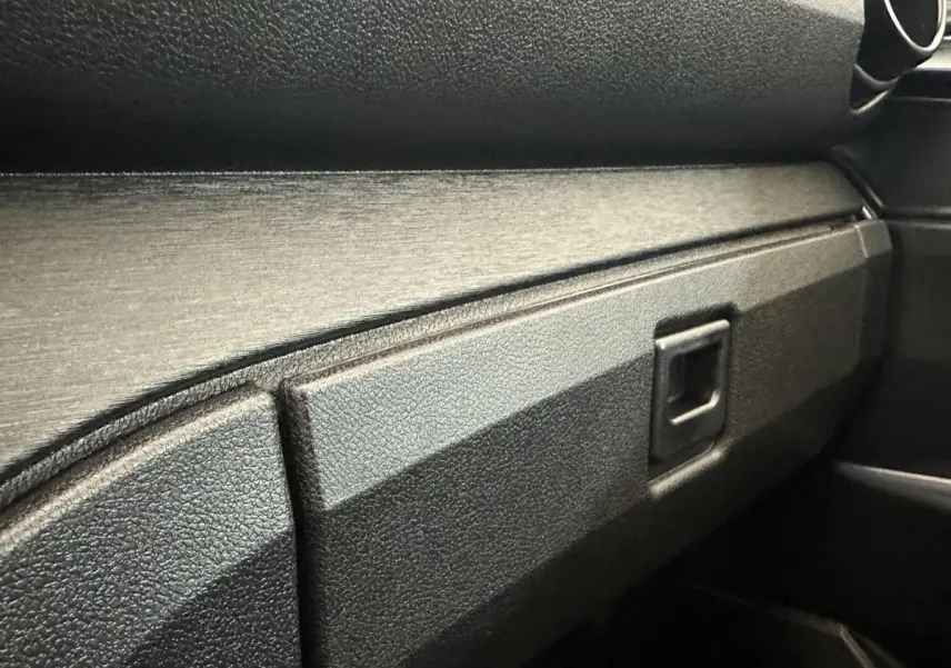 Détail de la boîte à gants noire dans l'habitacle de l'AIXAM AMBITION E CITY PACK 2025.