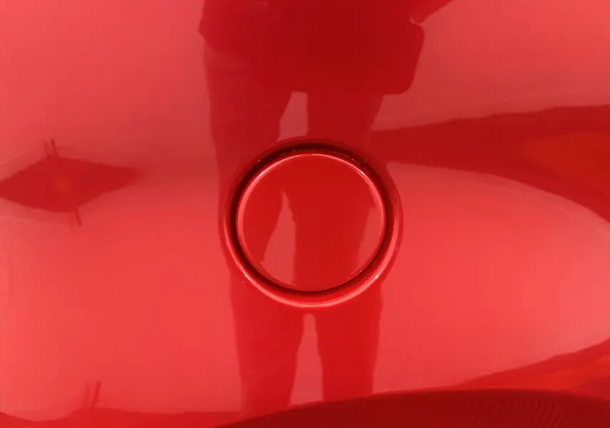 Gros plan sur la trappe de recharge rouge de l'AIXAM AMBITION E CITY PACK 2025, côté conducteur avec caméra intégrée.