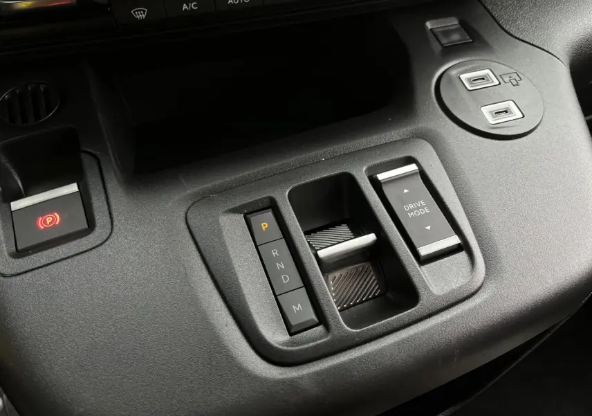 Gros plan sur la console centrale noire du Citroën Berlingo Multispace 2025 avec commandes boîte auto et mode de conduite.