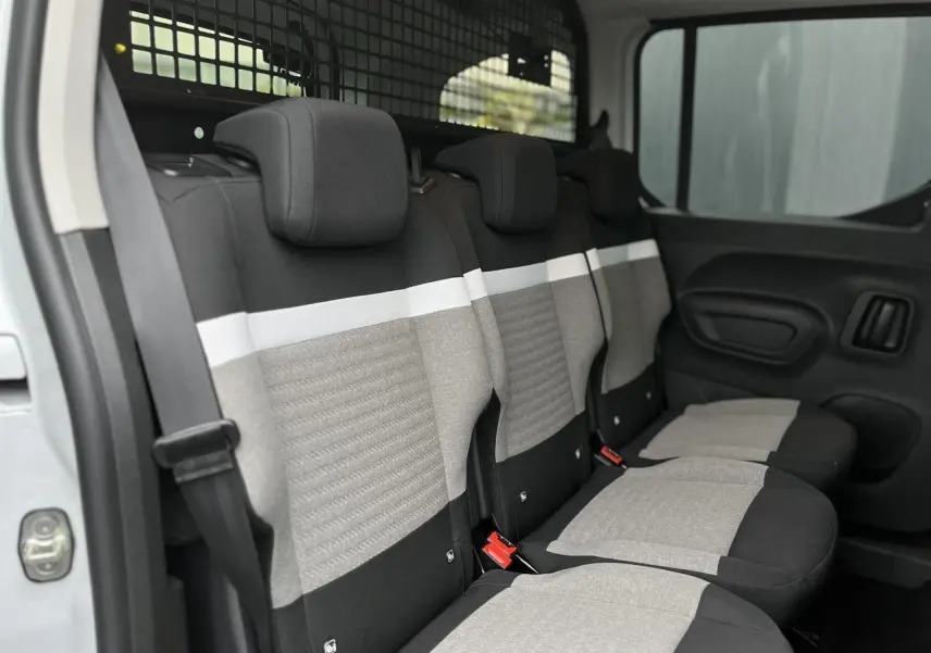Vue intérieure côté droit des sièges arrière gris et noirs du Citroën Berlingo Multispace blanc glacier avec lunette ouvrante.