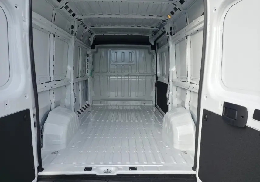 Vue intérieure arrière du fourgon FIAT Ducato blanc tôlé, montrant l'espace de chargement vide et les parois métalliques.