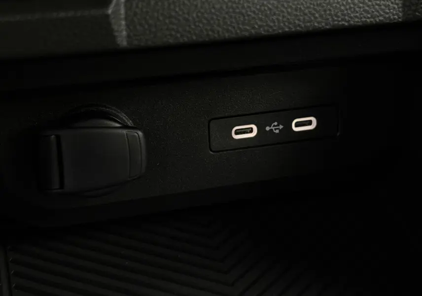Gros plan sur les ports USB-C et prise 12V noirs dans l'habitacle du Dacia Duster gris Schiste 2026.