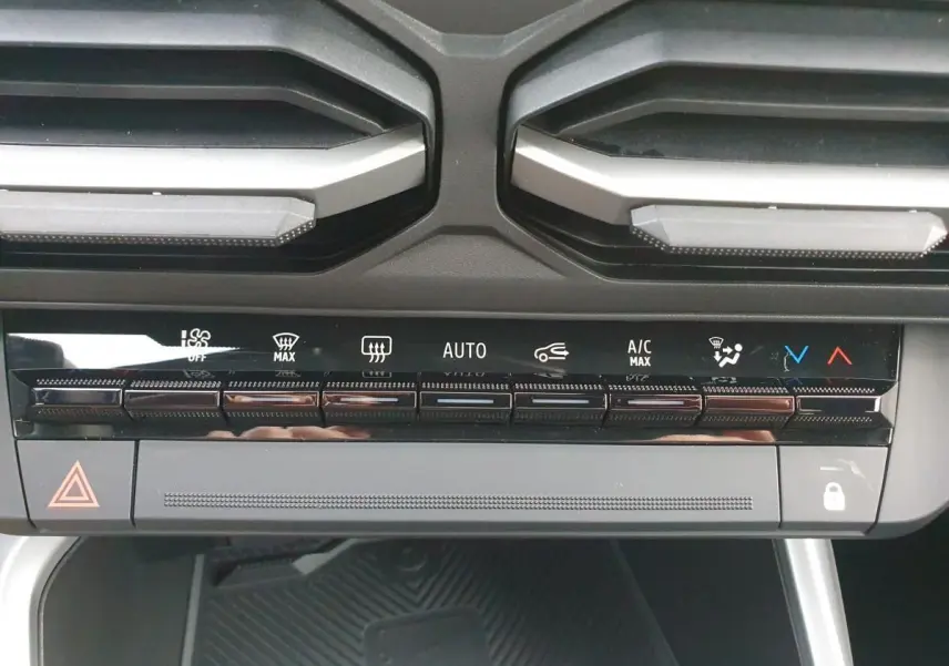 Gros plan sur la console centrale du Dacia Bigster 2026, montrant les commandes de climatisation automatique et les aérateurs noirs.