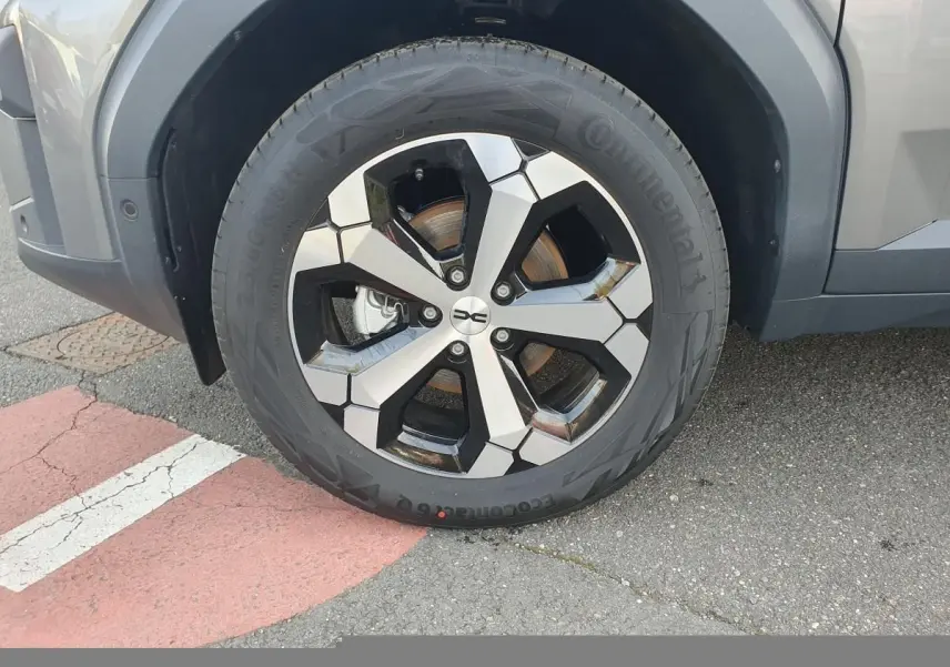 Gros plan sur la roue avant droite du Dacia Bigster gris schiste avec jante alliage 18” diamantée Tagasan.
