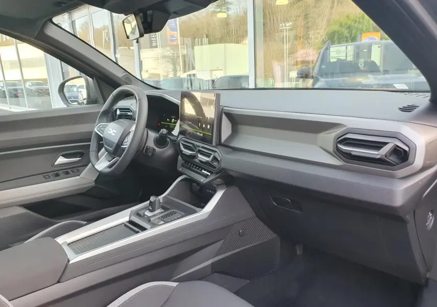 Vue intérieure côté conducteur du Dacia Bigster 2026, tableau de bord moderne avec écran tactile et volant multifonction.