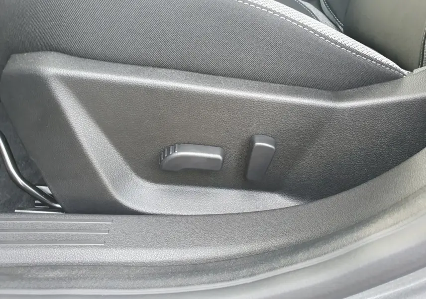 Gros plan sur les commandes de réglage lombaire du siège conducteur du Dacia Bigster, intérieur noir.