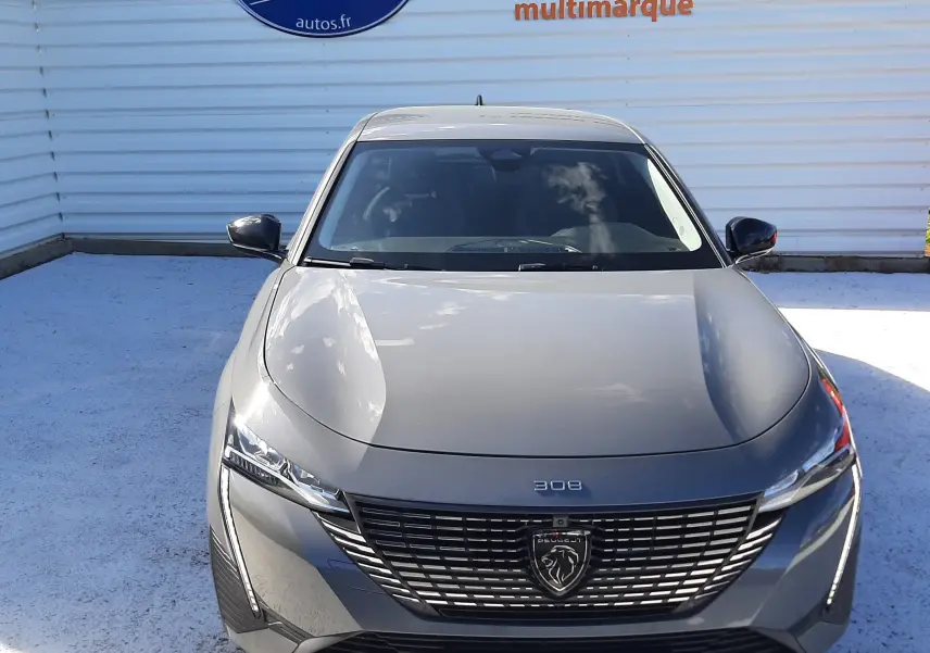 Vue avant frontale d'une Peugeot 308 SW gris selenium métal avec calandre noire et logo lion distinctif.