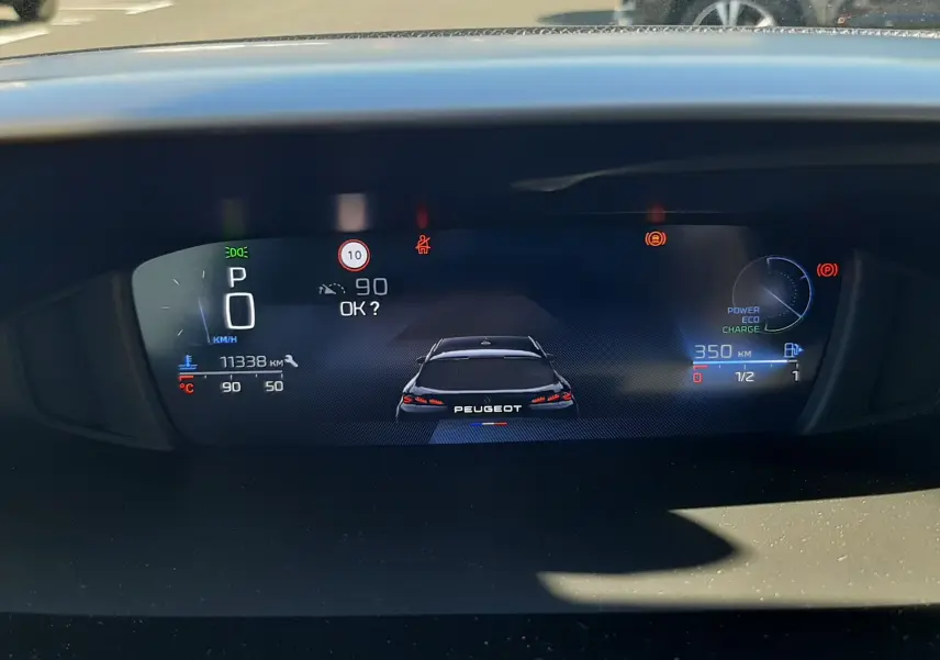 Affichage numérique du tableau de bord de la Peugeot 308 SW Hybrid, montrant la vitesse, autonomie et indicateurs de conduite.
